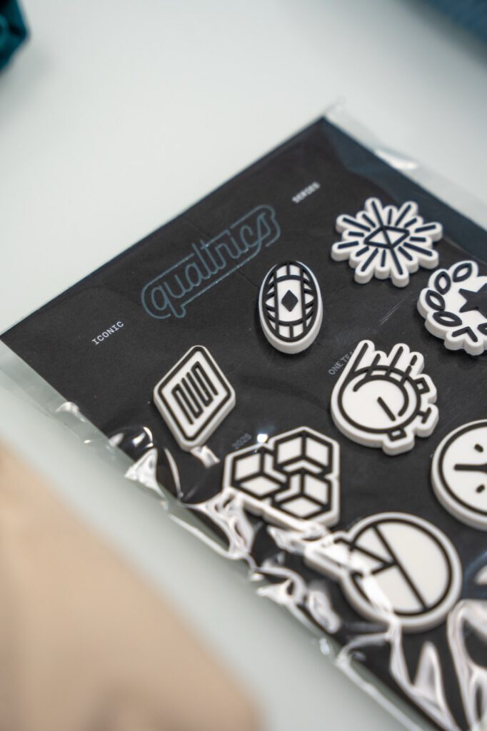 Custom-molded Qualtrics charm pack in its packaging