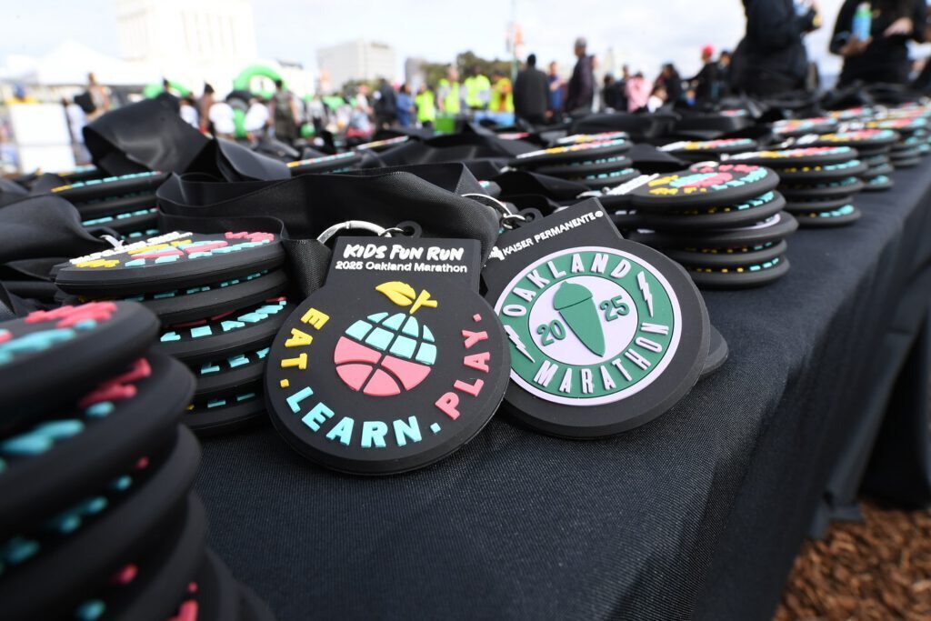 Custom rubber event medals spread across a table at an Eat Learn Play youth fun run