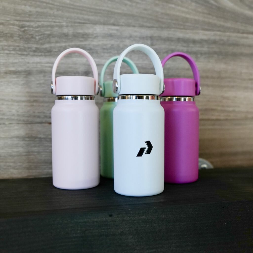 Pastel mini water bottles printed with the Prodigy chevron logo