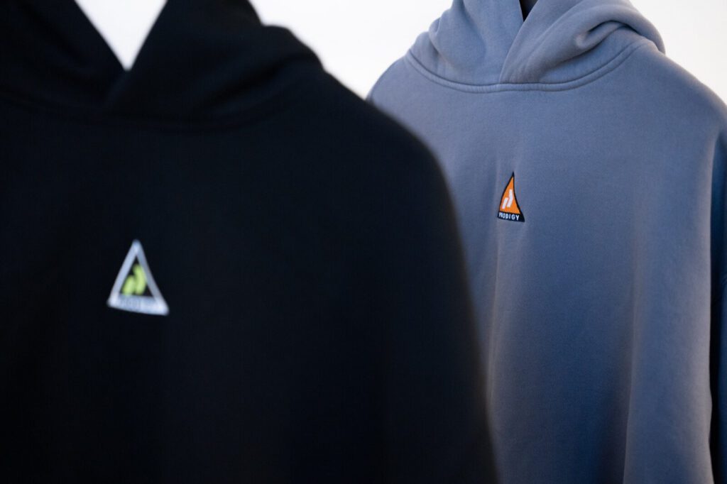 Two hoodies with embroidered Prodigy triangle patches on the chest
