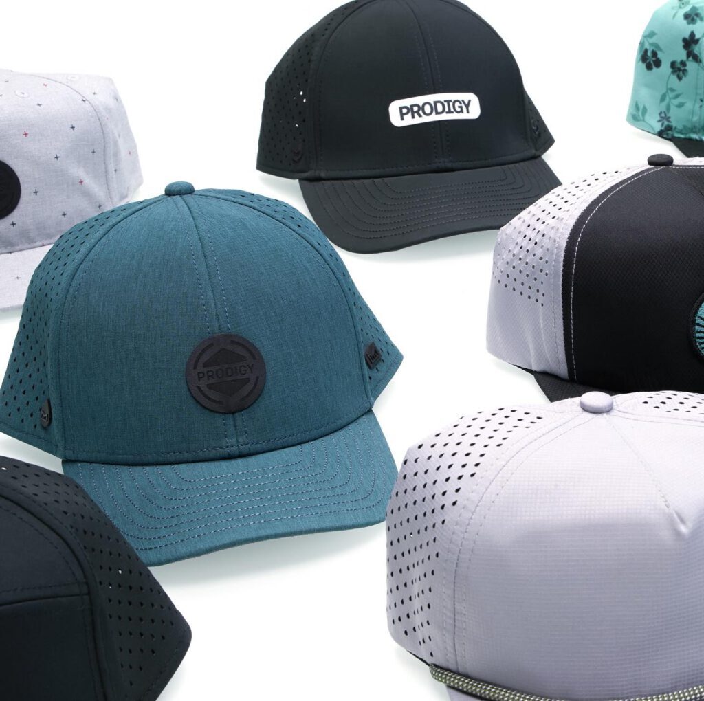 Group of Prodigy performance caps decorated with heat-applied patches in assorted colors and styles