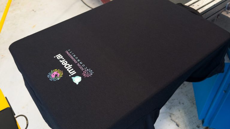 Full-color Digital Squeegee print on a black t-shirt on the press at Prodigy Promos in Lindon, Utah