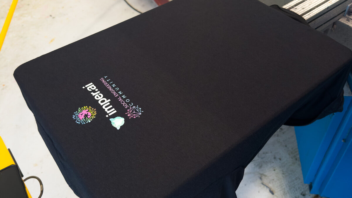 Full-color Digital Squeegee print on a black t-shirt on the press at Prodigy Promos in Lindon, Utah