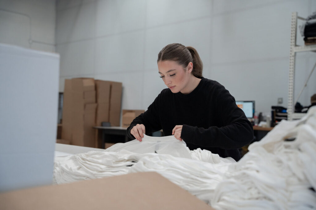 A Prodigy team member counting and checking blank garments before production in Lindon, Utah