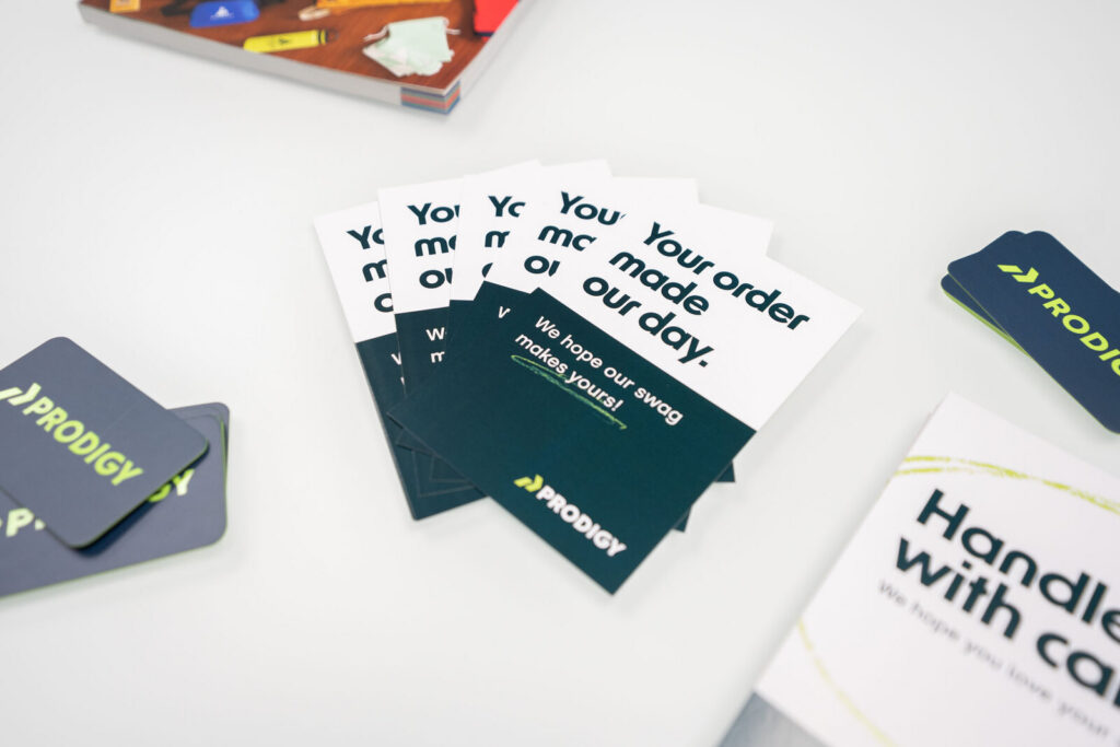 Prodigy-branded insert cards and printed pieces arranged on a white table