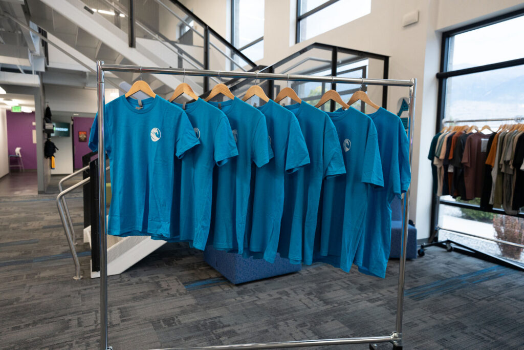 A rack of matching teal Costa Vida team member tees in the Prodigy showroom